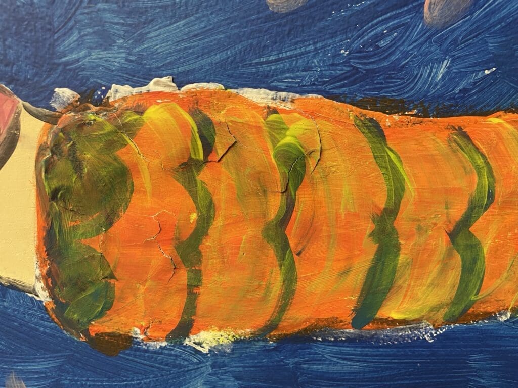 A vibrant orange fish with green stripes against a blue background.