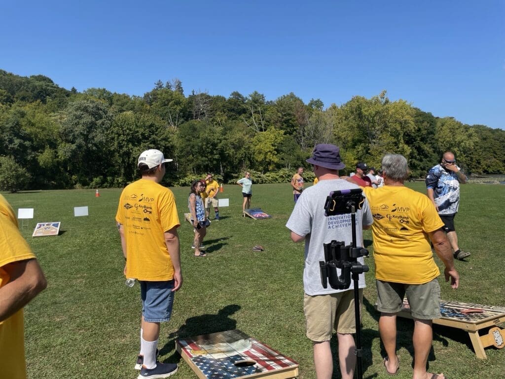 People playing a casual outdoor game on a sunny day.