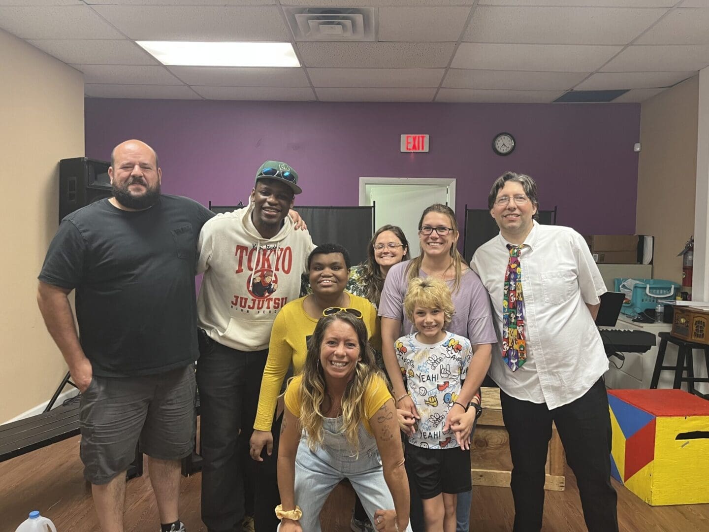 A diverse group of smiling people posing together indoors.
