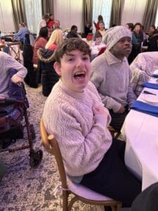 Guest laughing at dining table with others
