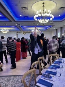 Tall guest dancing under blue chandeliers