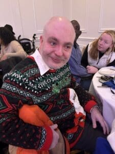 Man smiling in festive Christmas sweater