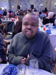 Smiling guest in gray coat at table