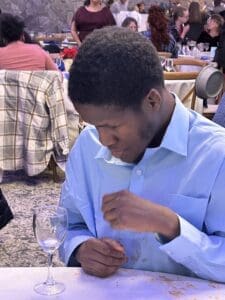 Young man seated at table with wine glass
