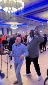 Two guests dancing under blue chandeliers