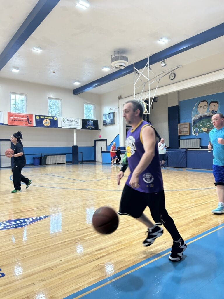 Player dribbling basketball on indoor court