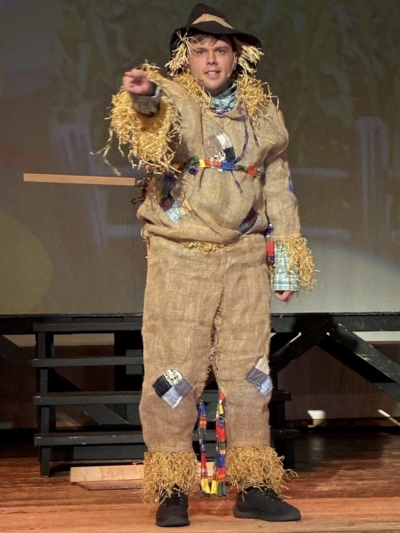 Person in burlap scarecrow costume pointing
