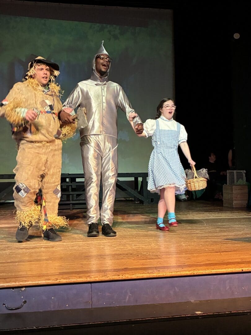 Dorothy, Tin Man, and Scarecrow on stage