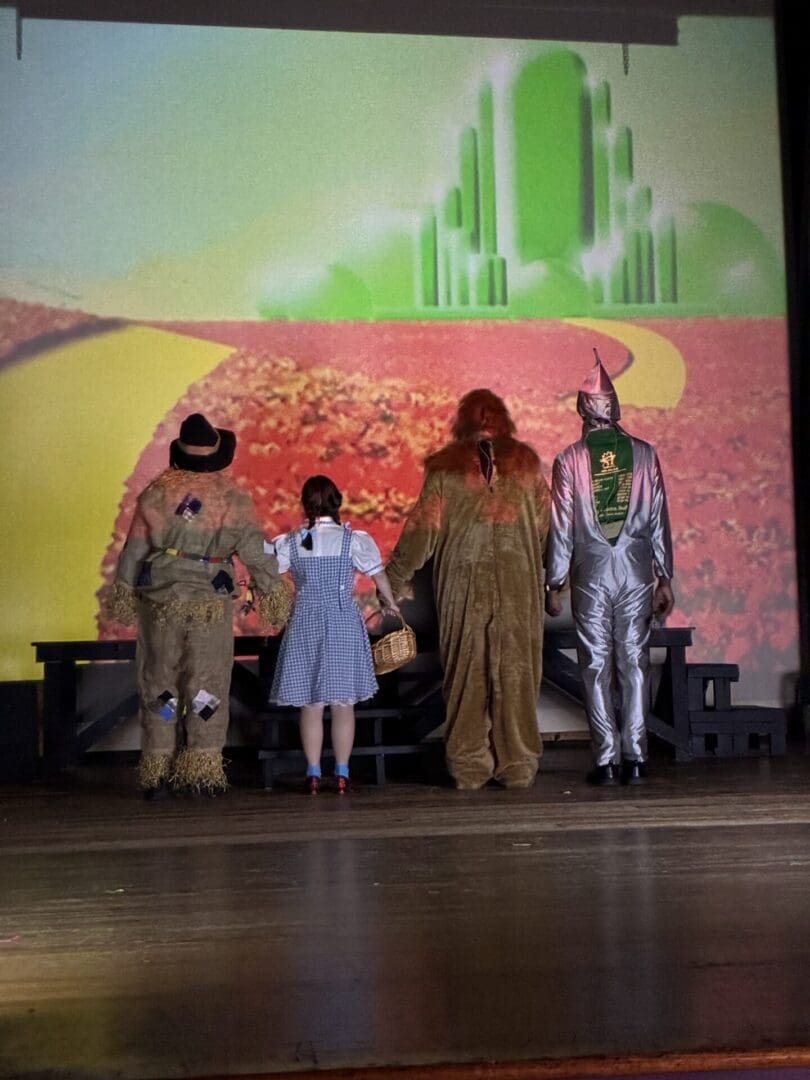 Four Wizard of Oz characters facing Emerald City